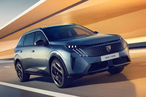 En blå Peugeot E-5008 glider fram på en väg, redo för ett spännande peugeot 5008 test.