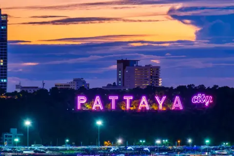 Neonowy napis "PATTAYA city" rozświetla wzgórze o zmierzchu. Idealne miejsce na wakacje!