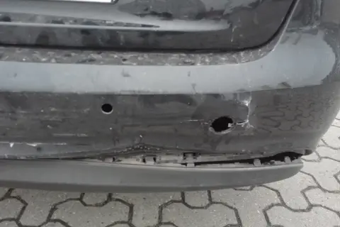 Uszkodzony zderzak po uderzeniu parkingowym: wgniecenia, pęknięcia i widoczne objawy uszkodzonych ślizgów zderzaka.