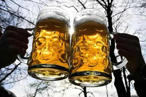 Dwa kufle piwa, złociste i orzeźwiające, unoszą się w blasku słońca. Czy to mocne piwo, jak Tatry?