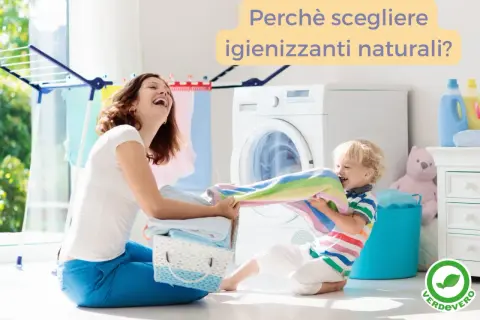 Mamma e bambino giocano con i panni colorati vicino alla lavatrice. Un invito a scegliere igienizzanti naturali per il lavaggio.