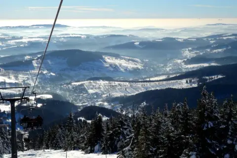 Blick vom Sessellift im Rokytnice Skigebiet auf verschneite Berge und Täler.