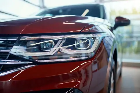 Detalle de faro de coche rojo con luces LED y catadióptricos que reflejan la luz.