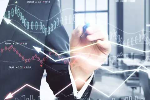 Biznesmen rysuje wykresy giełdowe i analizuje dane finansowe.