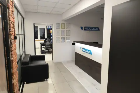 Nowoczesne biuro z recepcją, kanapą i widokiem na gabinet.