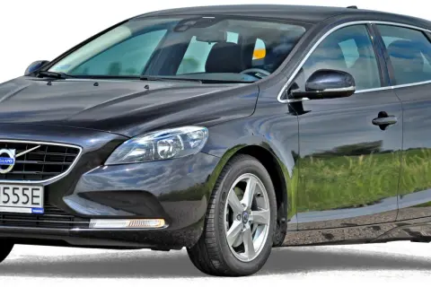 Czarne volvo hatchback z polskimi tablicami rejestracyjnymi WN 4555E, zaparkowane na tle zielonej trawy.
