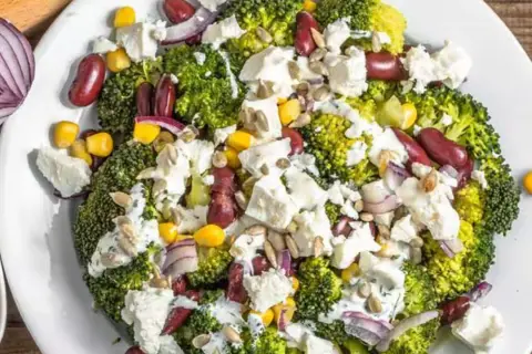 Ensalada de brócoli con frijoles rojos, maíz, queso feta y semillas de girasol. Un ejemplo de dieta saludable.