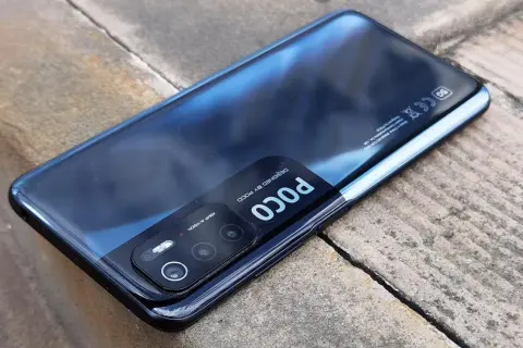 Czarny Xiaomi Poco M3 Pro z modułem aparatów 48MP AI VISION, leżący na kamiennym podłożu.