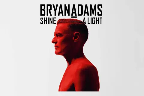 Bryan Adams Shine A Light. Okładka albumu z wizerunkiem artysty w czerwonym świetle.