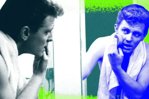 Visage homme 40 ans, se regardant dans le miroir, une serviette sur les épaules, appliquant un produit sur sa peau.