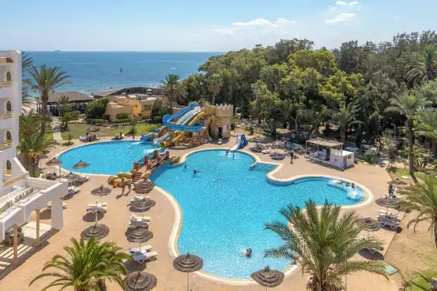 Basen z wodnymi zjeżdżalniami i palmami przy hotelu Marhaba Royal Salem.