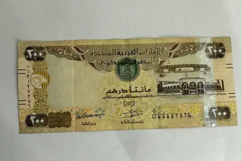 Banknot 200 dirhamów Zjednoczonych Emiratów Arabskich z wizerunkiem sokoła i budynków.