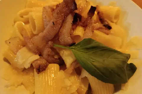 Makaron z chrupiącym guanciale, parmezanem i listkiem bazylii. To właśnie guanciale nadaje daniu wyjątkowy smak.