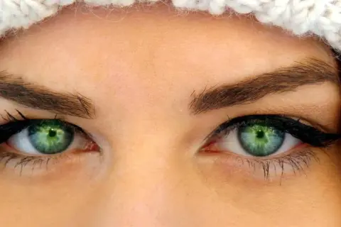 Oczy z zieloną tęczówką, podkreślone eyelinerem i tuszem, idealne dla tych, które szukają odpowiedzi na pytanie: jakie rzęsy do opadającej powieki.