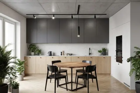 Nowoczesna kuchnia z wyspą, okrągłym stołem i krzesłami. Nad nimi wisi elegancka lampa led slim, oświetlając wnętrze.