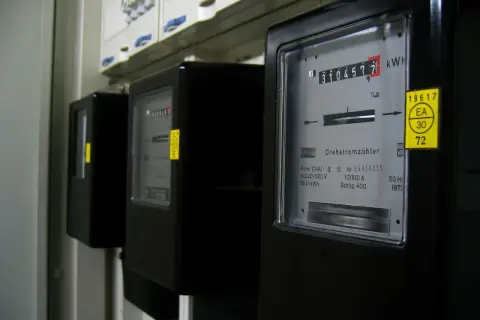 Liczniki przedpłatowe, jak doładować licznik? Na zdjęciu widać rząd czarnych liczników energii elektrycznej.