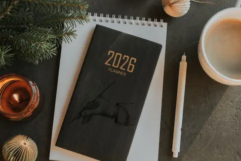 Planer 2026, świeca, kawa i gałązka choinki. Zastanawiasz się, czy jest podatek od darowizny?