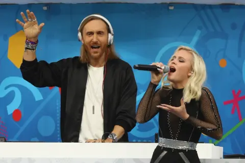 David Guetta Polska: DJ z mikrofonem i wokalistka na scenie, bawią publiczność.