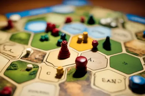 Plansza do gry Catan, pionki i zasady gry.