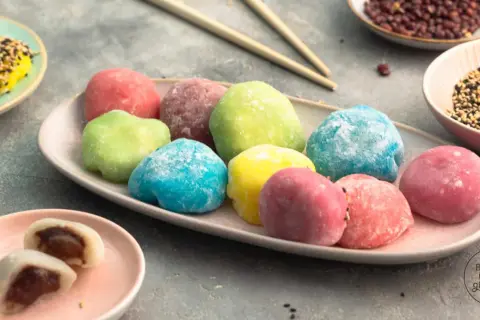 Bunte Mochi-Bällchen, ein köstliches Rezept für süße Leckereien. Auf einem Teller liegen sie in verschiedenen Farben, bereit zum Genießen.
