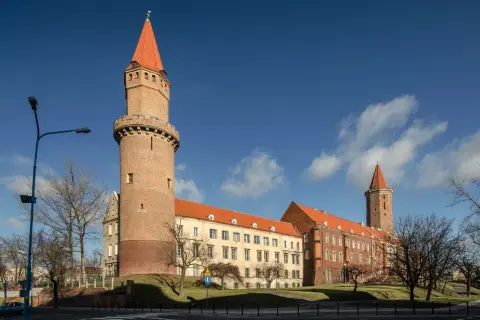 Zamek Piastowski w Legnicy, jedna z głównych atrakcji miasta, z charakterystyczną wieżą i czerwonym dachem.
