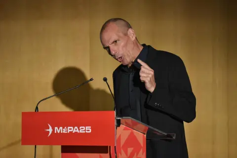 Mann spricht an Rednerpult mit "MÉPA25"-Logo. Seine Mimik deutet auf Kritik hin.