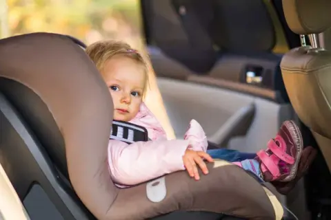 Kleines Mädchen im Kindersitz, ADAC-Sicherheit im Auto, egal ob rechts oder links.