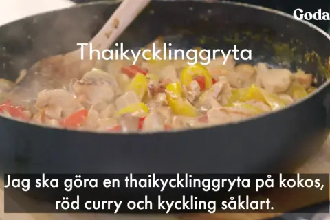 En thaikycklinggryta med kycklingbitar, gul och röd paprika i en krämig sås i en stekpanna.