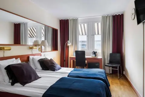 Dubbelrum med två sängar, mörkläggningsgardiner, skrivbord och spegel. Ett bekvämt och funktionellt rum på detta **sure hotel**.