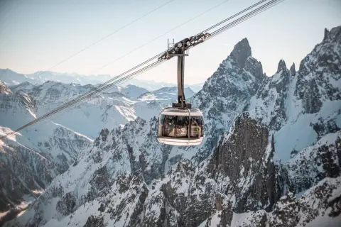 Cabina della funivia sorvola montagne innevate, un'esperienza imperdibile per scoprire Courmayeur cosa vedere.