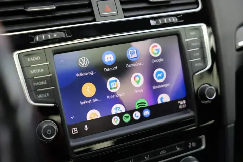 Ekran samochodu z ikonami aplikacji: Volkswagen, Discord, Mapy, Google, Messenger. Widoczne są też przyciski Radio, Media, Phone, Voice. To są android auto ustawienia.