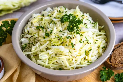 Frischer spitzkohl salat mit Kümmel und Petersilie, garniert mit einem Petersilienzweig.