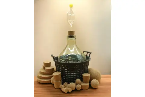 Wino w balonie z rurką fermentacyjną i korkami. Złe zamknięcie to powód, dlaczego wino kwaśnieje.