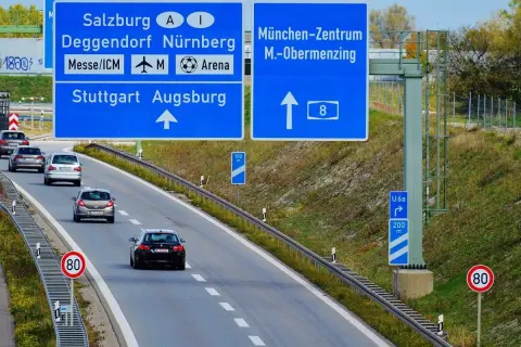 Autostrady w Niemczech: znaki kierunkowe do Salzburga, Norymbergi, Stuttgartu, Augsburgu i centrum Monachium. Ruch samochodowy.
