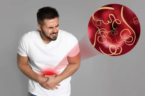 Mężczyzna z bólem brzucha, symbolizującym pasożyty. W okręgu widoczne są robaki, sugerujące pasożyty objawy psychiczne.