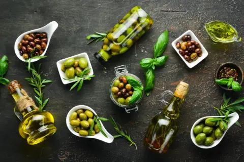 Diverse olive, in ciotole e bottiglie, con olio e basilico. Chissà quanto pesa un oliva, ma sono perfette per un antipasto.