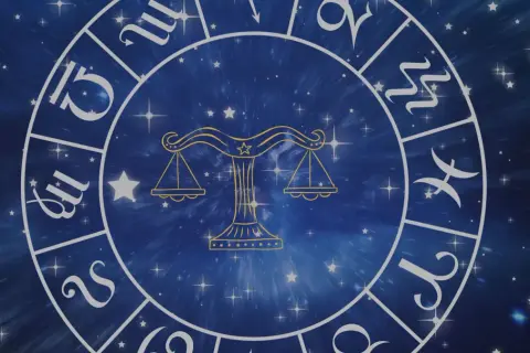 Zodiakalny krąg z symbolem Wagi w centrum. Wokół widoczne inne znaki powietrzne i gwiezdne tło.