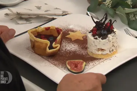 Omas eistorte: eine zarte Eistorte mit Schokostückchen, Beeren und einem Keksstern, daneben ein Körbchen mit Früchten.