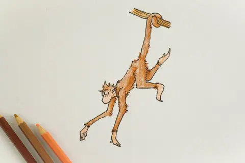 Dibujo de un mono naranja colgado de una rama, con lápices de colores al lado.