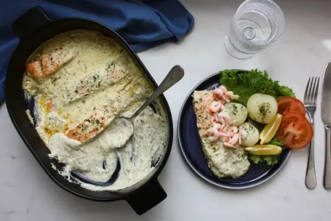 Laxpasta i ugn med krämig sås, serverad med räkor, potatis, tomat och citron. En härlig middag!