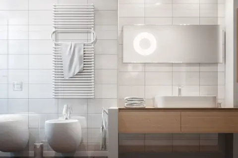 Bagno moderno con termoarredo bianco a parete, ideale per capire dove posizionare termoarredo bagno per asciugare gli asciugamani.