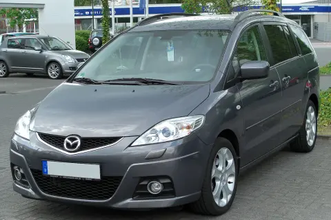 Szary minivan Mazda 5 na parkingu. Wiele osób szuka mazda 5 opinie, ten model jest dobrym wyborem.