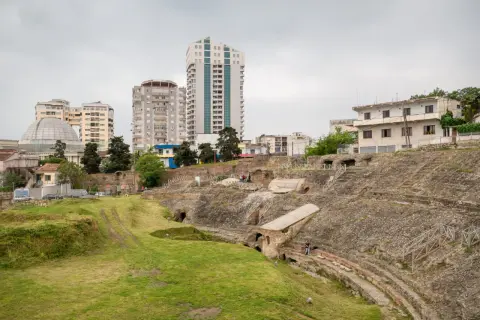 Ruiny amfiteatru w Durres, Albania, kontrastują z nowoczesnymi budynkami w tle.