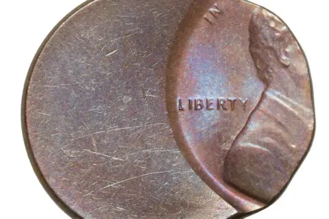 Zniszczona moneta z napisem "LIBERTY". Widać ślady użytkowania i drobne uszkodzenia.