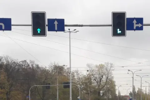 Sygnalizacja świetlna z zieloną strzałką do przodu i w prawo, zieloną strzałką do przodu, czerwoną strzałką w lewo. Znak S3 informuje o dozwolonych kierunkach jazdy.