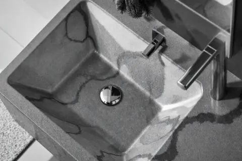 Lavabo évier moderne en béton gris veiné, avec robinetterie chromée. Un design épuré pour une salle de bain contemporaine.