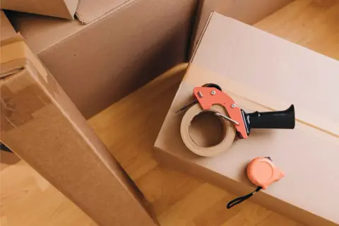 Umzugskartons, Klebebandabroller und Maßband liegen bereit. Perfekt, um Dinge nach eigenbedarf wieder zu vermieten oder zu verkaufen.
