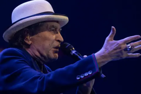 Joaquín Sabina, con su sombrero blanco y chaqueta azul, canta en Zaragoza.