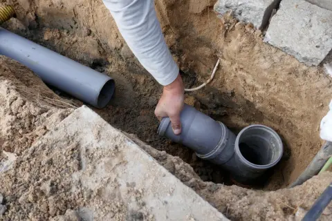 Hand verbindet ein Rohrstück mit einem Abzweig. Dies ist Teil der Installation, um die wasserleitung frostsicher isolieren zu können.