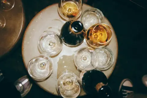 Naczynia z winem tworzą bukiet smaków i aromatów. Kilka kieliszków z bursztynowym trunkiem i ciemne butelki czekają na degustację.